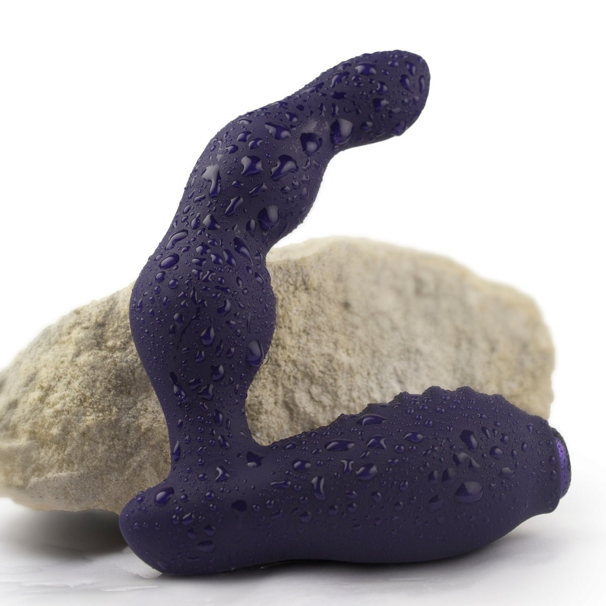 Rocks Off Dominion Rechargeable Prostate Massager next to rock with water drops
